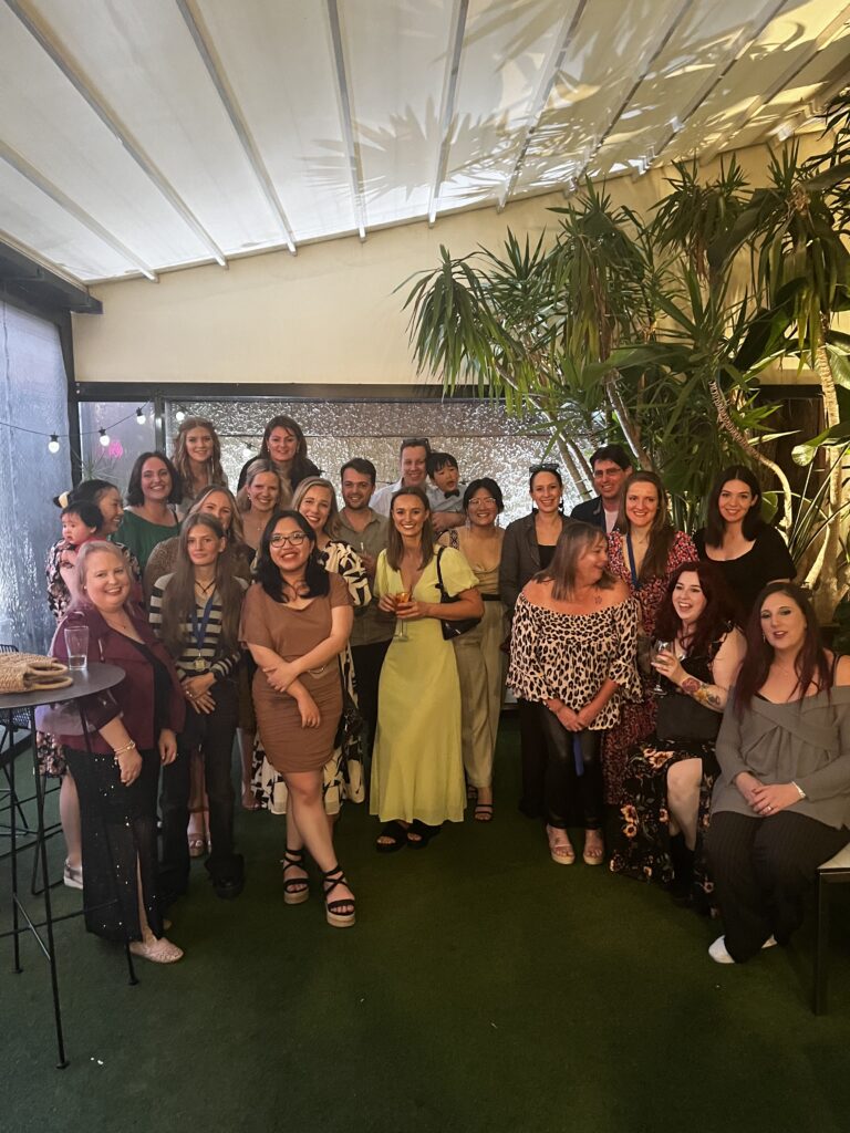 Narre Warren Veterinary Hospital team gathered together, smiling and celebrating during their annual Christmas party surrounded by greenery and festive decor
