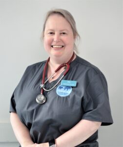 Smiling veterinary nurse wearing scrubs and a stethoscope, representing Nurse Ally’s top puppy training tips.